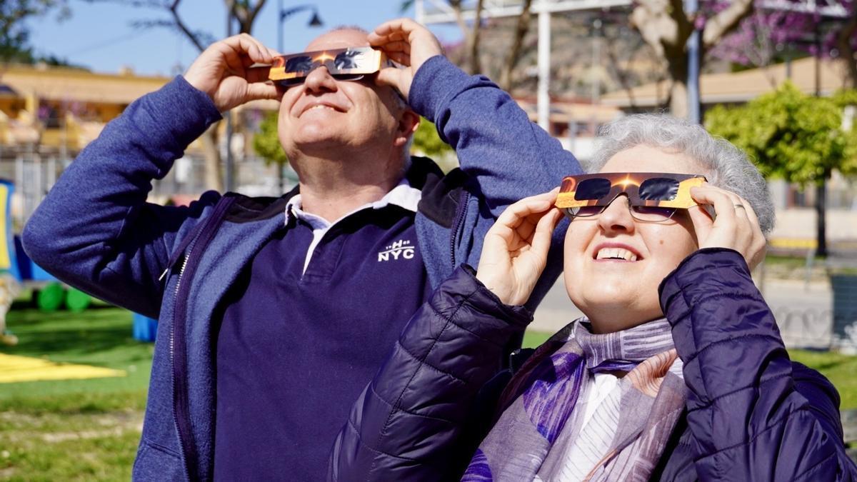 Una pareja contempla un eclipse con una gafas especiales para ello.