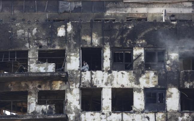 Un agente de la Policía Científica, en el interior del edificio quemado.