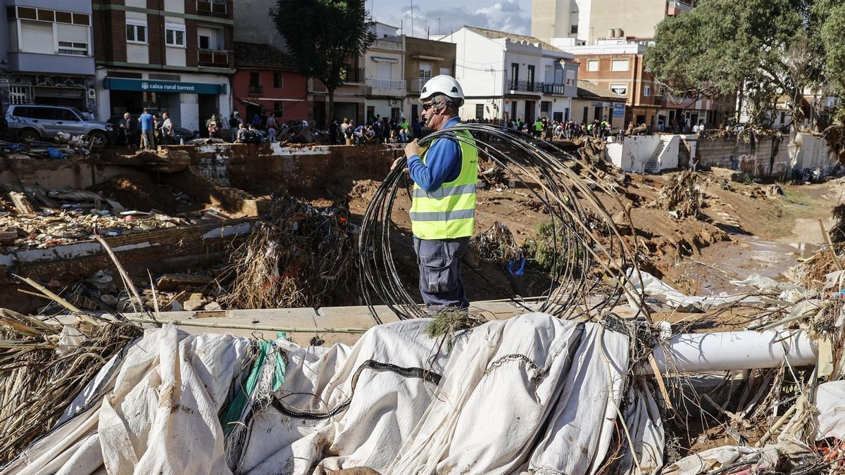 Un hombre limpia los estragos ocasionados por la DANA en Paiporta