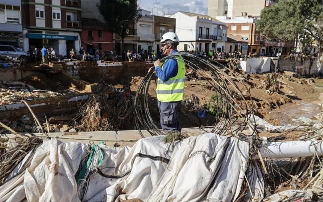 Un hombre limpia los estragos ocasionados por la DANA en Paiporta