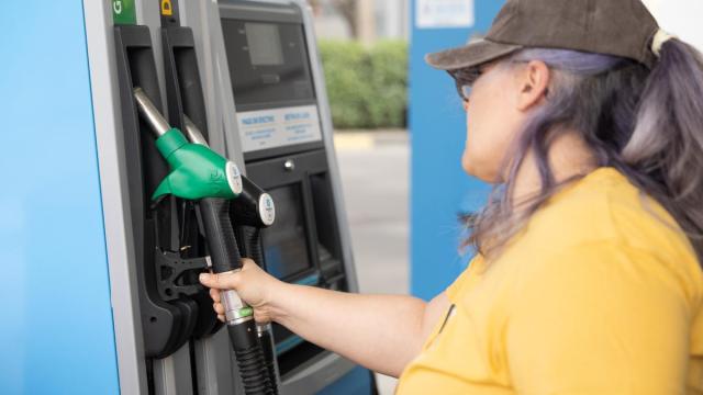 Una mujer repostando gasolina.