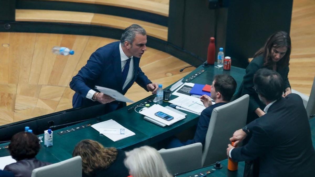 Momento en el que el portavoz de Vox en el Ayuntamiento de Madrid, Javier Ortega Smith, se encara y tira unos papeles y una botella de agua vacía al edil Eduardo Fernández Rubiño.
