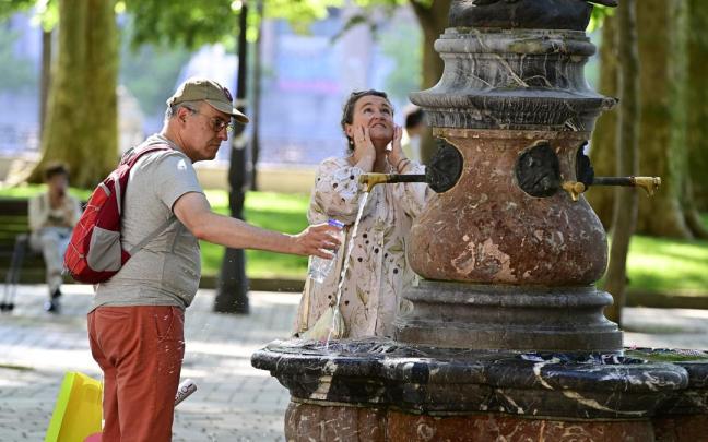 Dos personas se refrescan en una fuente de Bilbao / Óskar González
