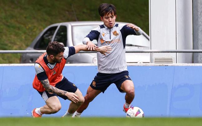 Take Kubo intenta avanzar con el balón, ante la presión de Javi Galán, en el entrenamiento ayer. / REAL SOCIEDAD