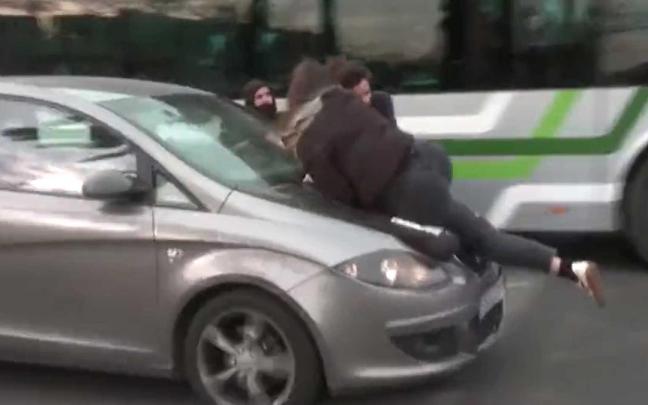 Tres manifestantes sobre el capó del coche. Tres manifestantes sobre el capó del coche.