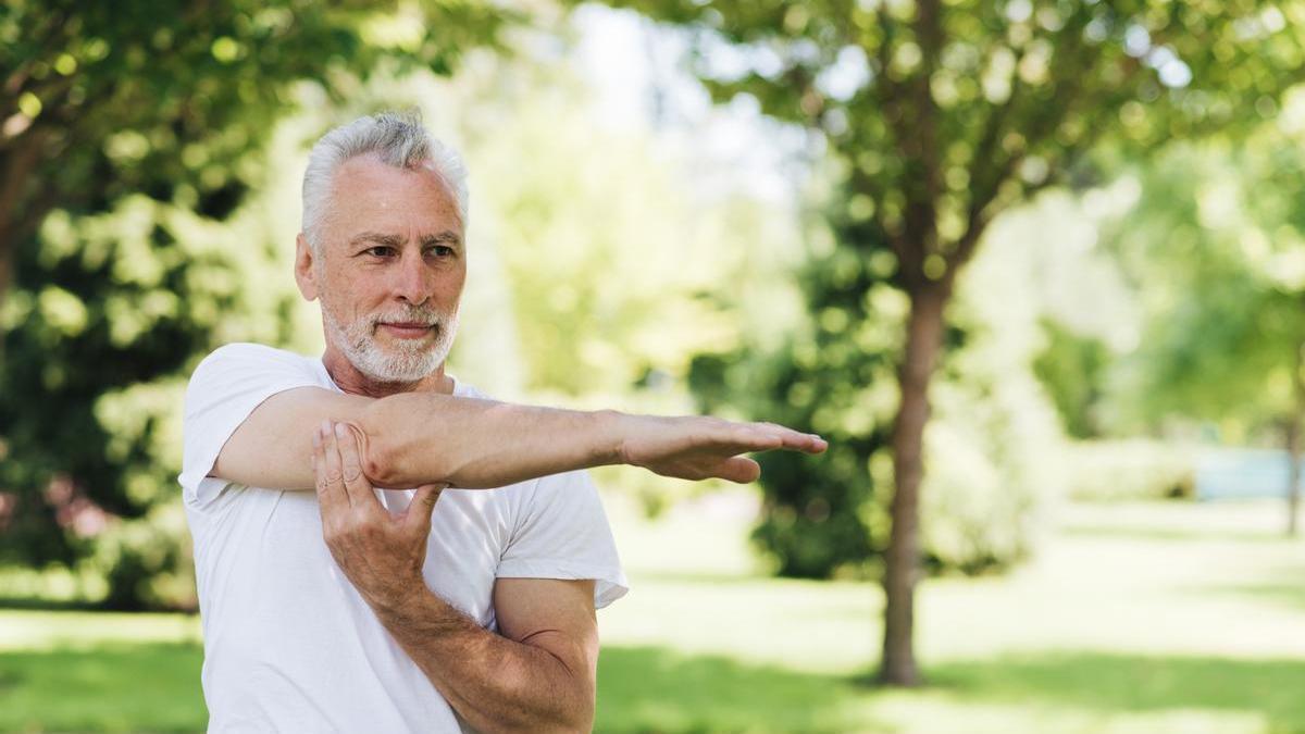 Hombre realiza estiramientos al aire libre.