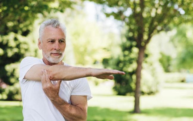 Hombre realiza estiramientos al aire libre.