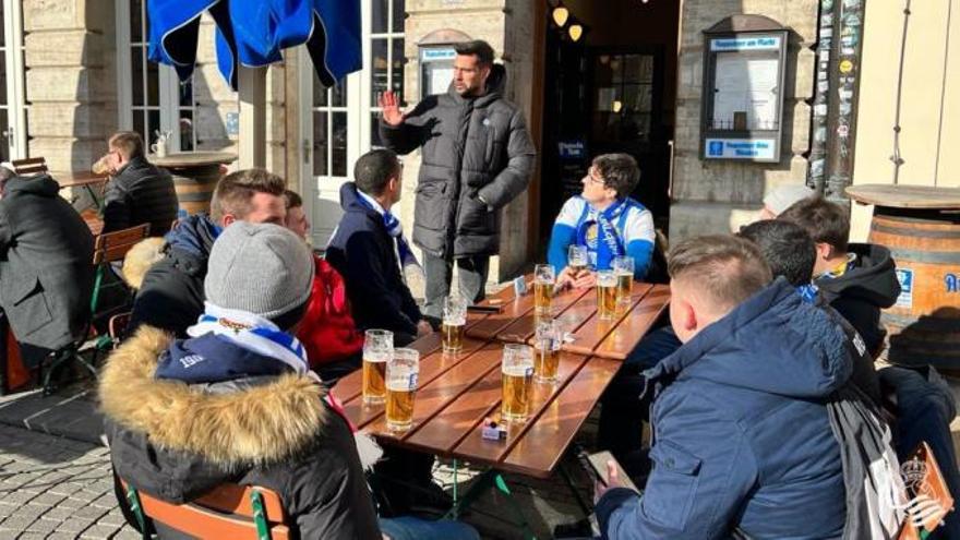 Aficionados realistas desplazados a Leipzig charlan con Miguel Ángel Moyá en una cervecería de Leipzig, en febrero de 2022.