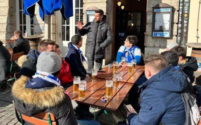 Aficionados realistas desplazados a Leipzig charlan con Miguel Ángel Moyá en una cervecería de Leipzig, en febrero de 2022.