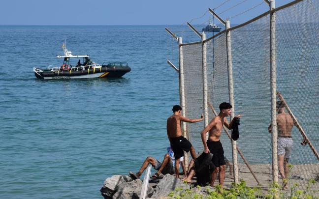 Varias personas cruzan la frontera en Ceuta.