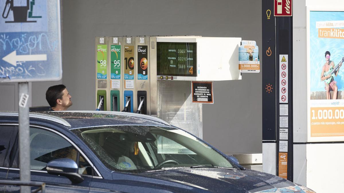 Un coche reposta en una gasolinera con el precio de los carburantes encadenando esta semana una nueva bajada.