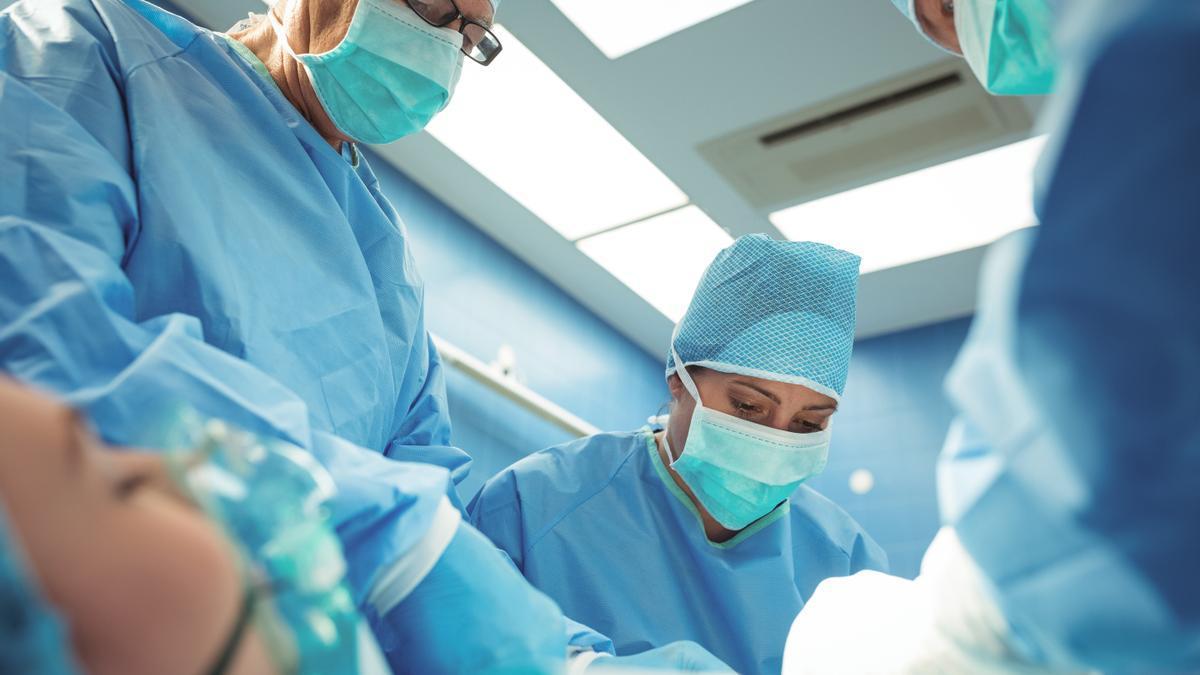 Equipo de cirujanos realizando una intervención en quirófano.