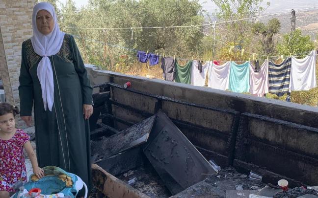 Mahazen Arman junto a su nieta muestra los destrozos causados en su casa de Jit por los colonos.