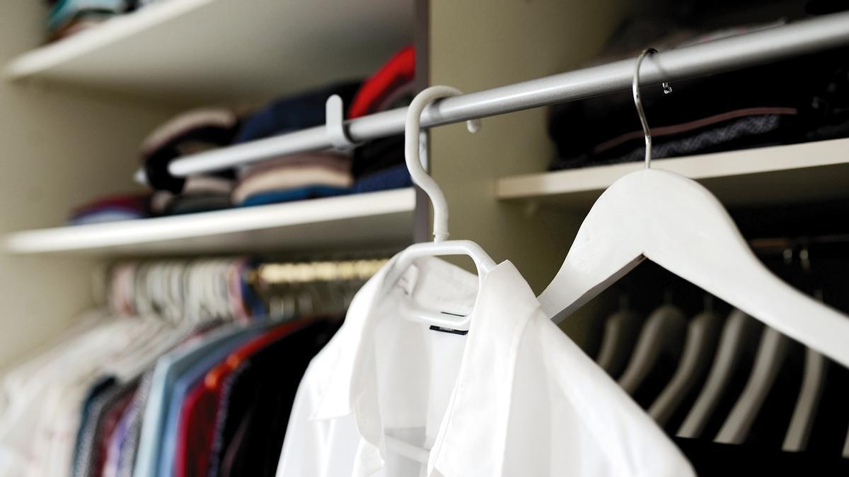 Camisa blanca colgada en una percha en el armario