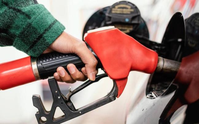 Una persona pone gasolina a su vehículo en una estación de servicio.