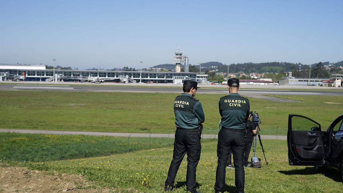 Dos guardia civiles esperan la llegada del rey emérito al aeropuerto de Vigo.
