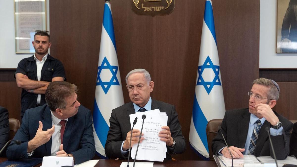 Benjamin Netanyahu (c) junto al ministro de Exteriores, Eli Cohen (i), y el secretario de gabinete Yossi Fuchs (d) durante la reunión semanal de su Ejecutivo.