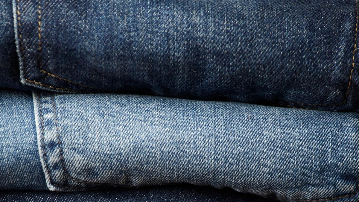 Pantalones vaqueros de distintos tonos doblados y apilados.