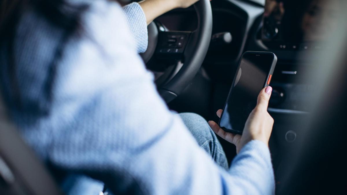 Una mujer utiliza el teléfono móvil mientras conduce.