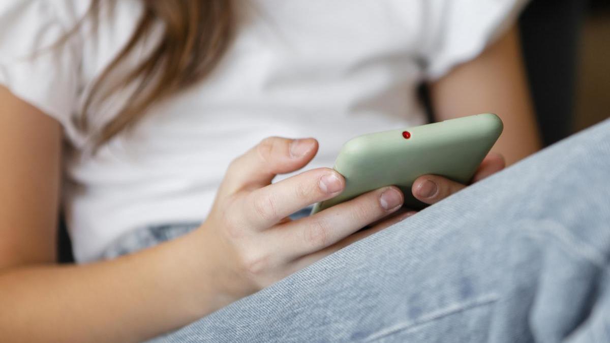 Joven escribe en su teléfono móvil