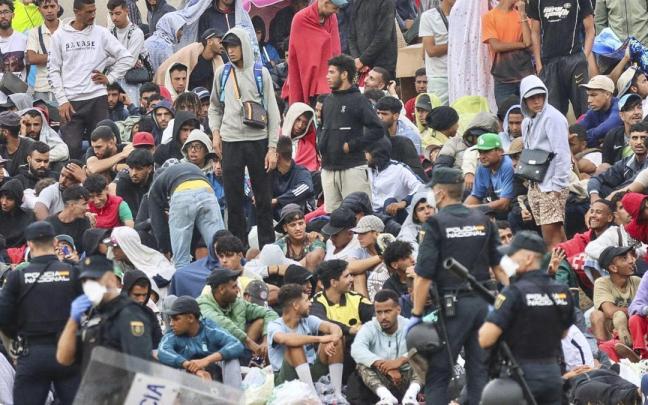 Policías desalojan a migrantes que permanecían en la playa del Trampolín en Ceuta.