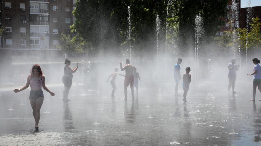 Varias personas se refrescan en un parque