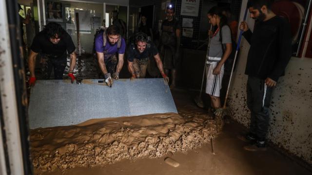 Varias personas ayudan a limpiar los locales inundados por la dana de Valencia