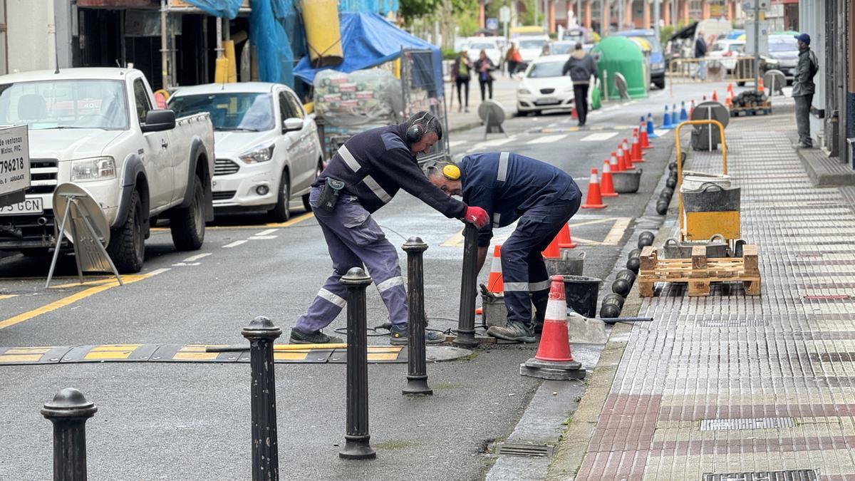 Operarios retirando este martes los pivotes de la calle Zarugalde.