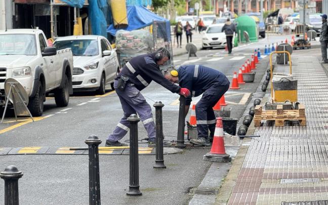 Operarios retirando este martes los pivotes de la calle Zarugalde.