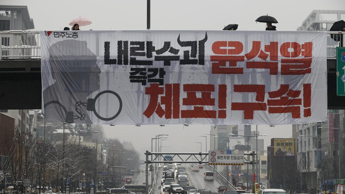 Un cartel en Seúl, Corea del Sur, que pide el arresto del "líder de la rebelión", el presidente Yoon Suk Yeol, "inmediatamente".