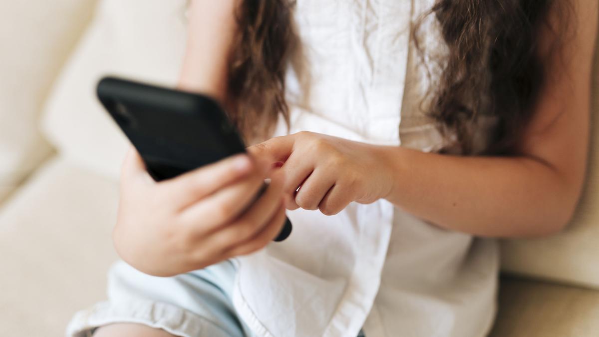 Una joven utiliza un teléfono móvil.