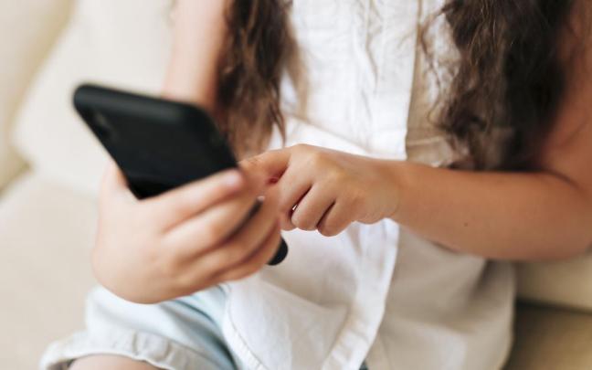 Una joven utiliza un teléfono móvil.