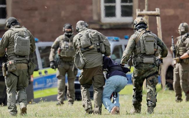 Agentes de la policía alemana trasladan al autor del atentado en Solingen.