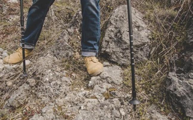 Un mendizale junto a un mojón