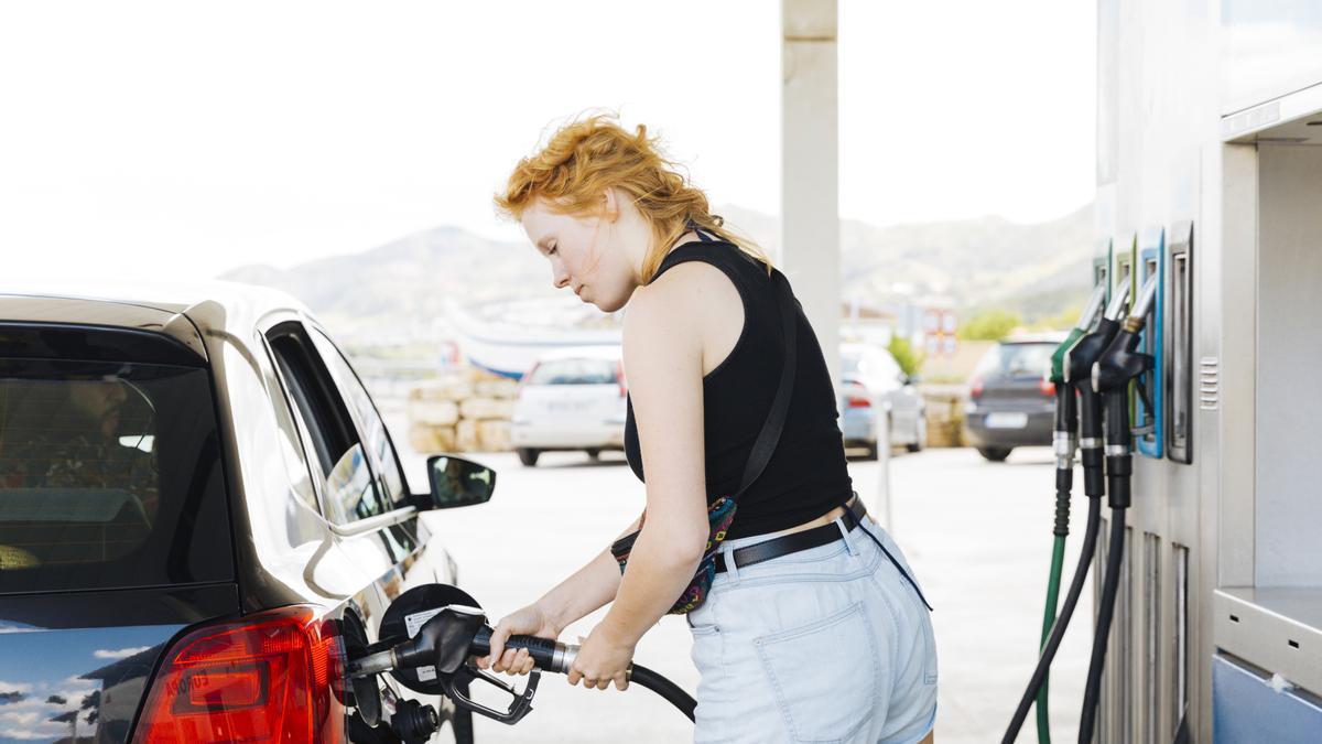 Una mujer llena el depósito de su coche en una gasolinera.