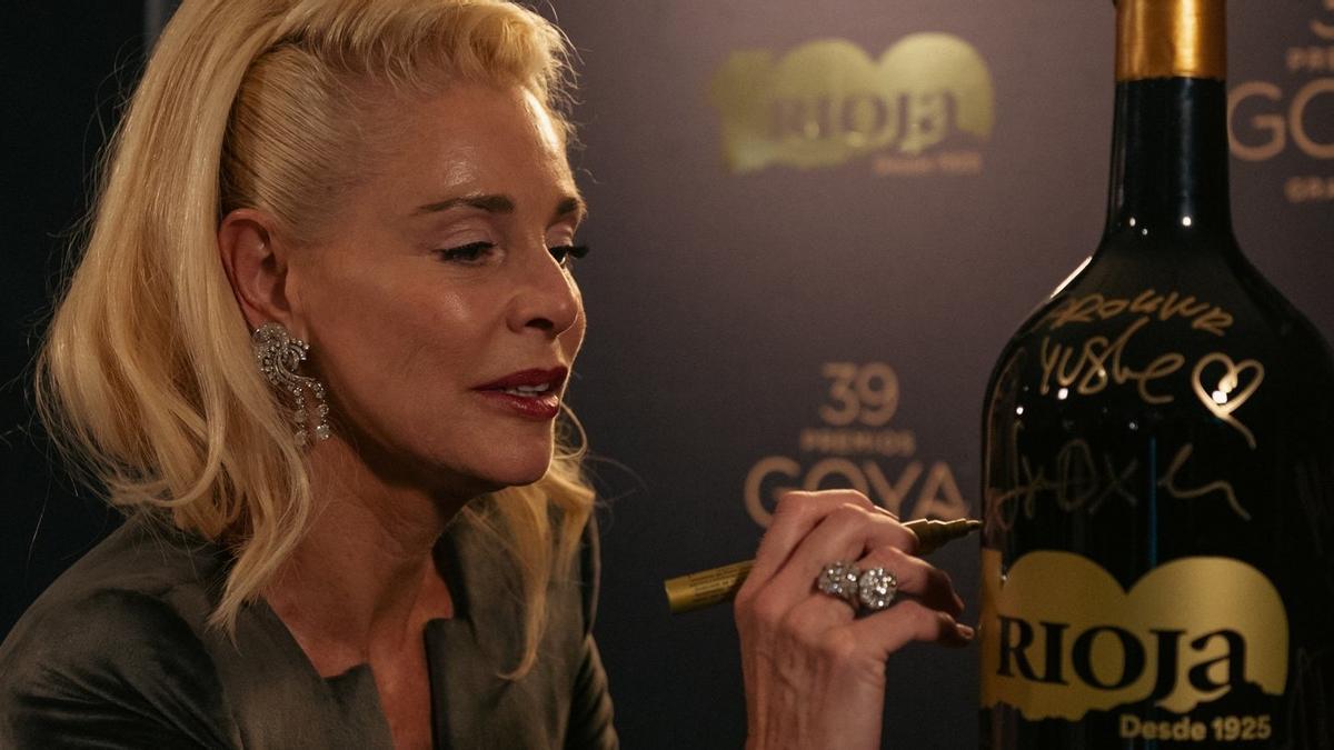 La actriz Belén Rueda firma una de las botellas especiales de Rioja del centenario que han desaparecido tras los Goya