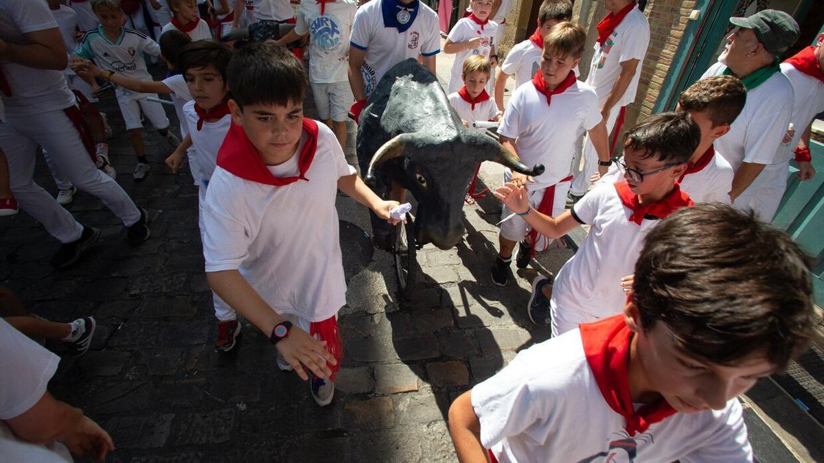 Niños corriendo delante de los toros en el encierro txiki.
