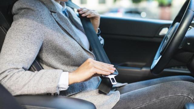 Una mujer se abrocha el cinturón de seguridad.