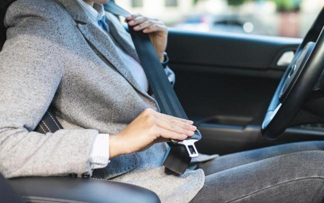 Una mujer se abrocha el cinturón de seguridad.