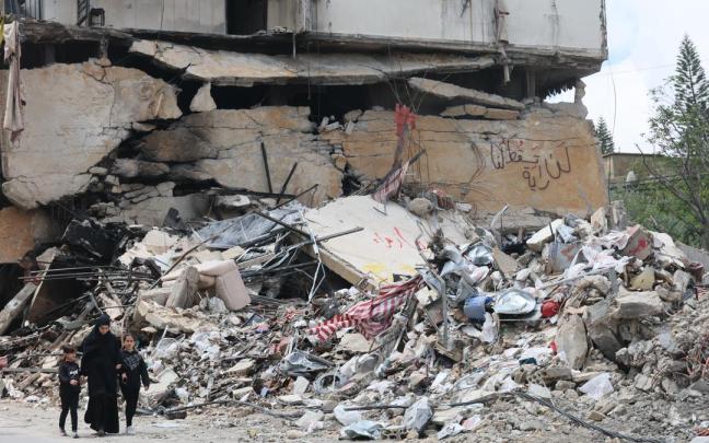 Libaneses caminan junto a los escombros de un edificio dañado por un ataque aéreo israelí en el sur.
