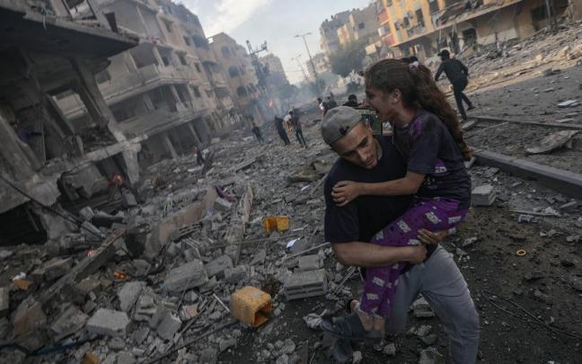 Un hombre traslada a una niña herida en un bombardeo israelí en Gaza.