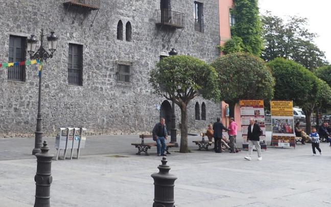 Un grupo de vecinos conversa a la sombra de los árboles que se van a empezar a retirar a partir del lunes.