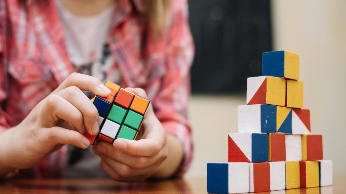 Un niño trata de resolver un cubos de Rubik.