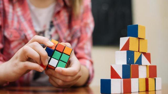 Un niño trata de resolver un cubos de Rubik.