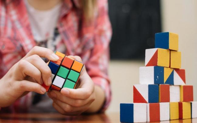 Un niño trata de resolver un cubos de Rubik.