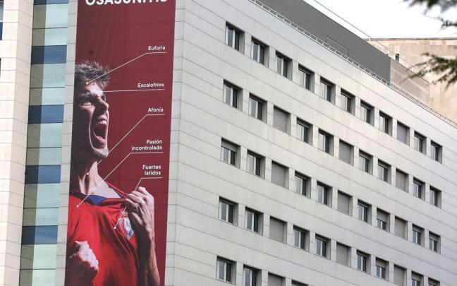 La pancarta ocupa de arriba abajo un lateral de la fachada de la CUN