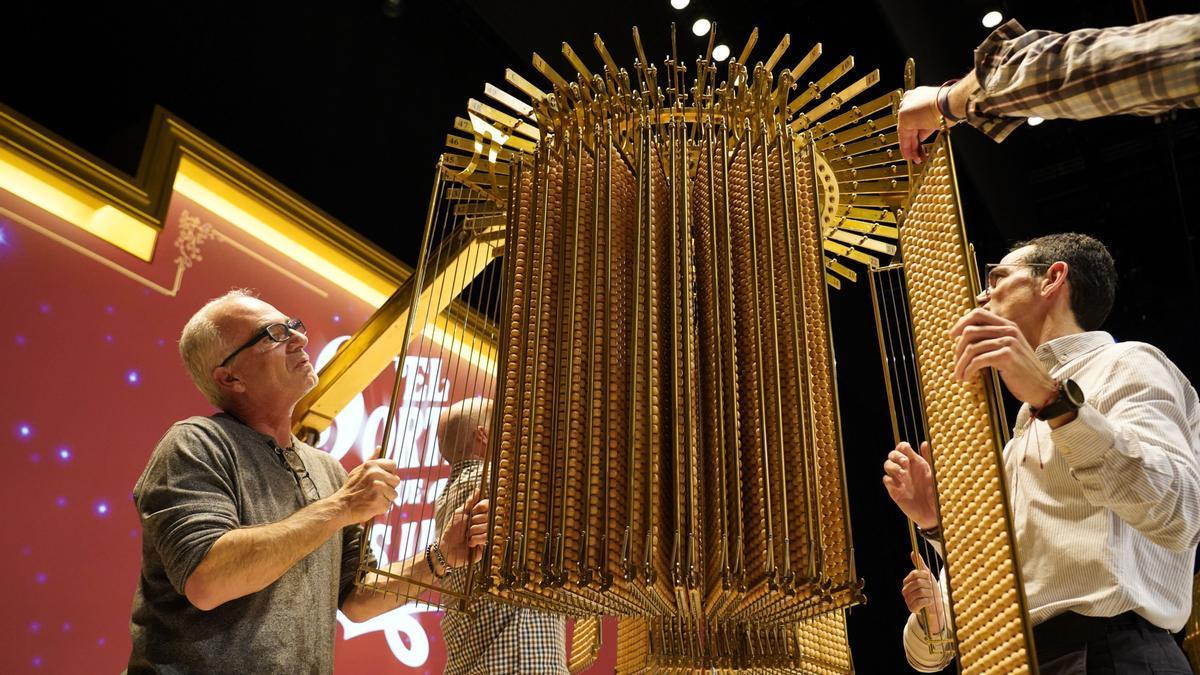 Personal de Loterías y Apuestas del Estado cuelgan las liras con las bolas del sorteo de la Lotería de Navidad.