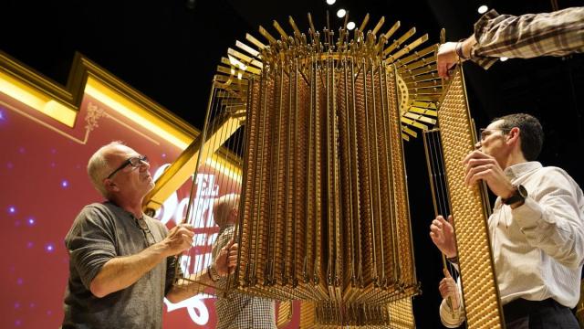 Personal de Loterías y Apuestas del Estado cuelgan las liras con las bolas del sorteo de la Lotería de Navidad.