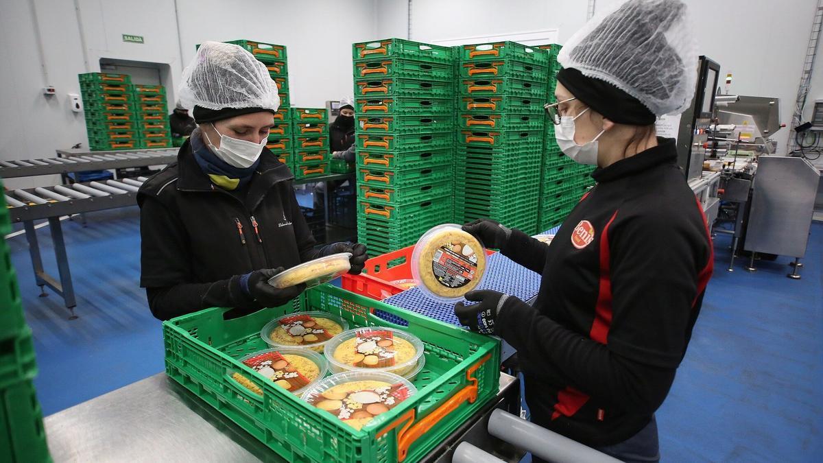 Empleadas trabajando en la cadena de producción de una empresa de alimentación.