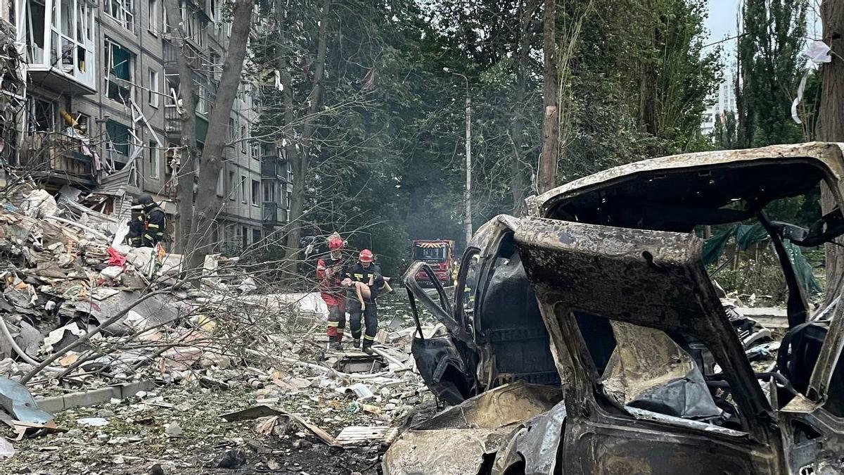 Los bomberos trasladan a uno de los menores heridos en el ataque en Kiev.